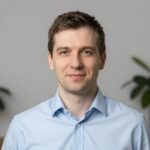 Портрет уверенного российского предпринимателя с дружелюбным взглядом на нейтральном размытом фоне в студии